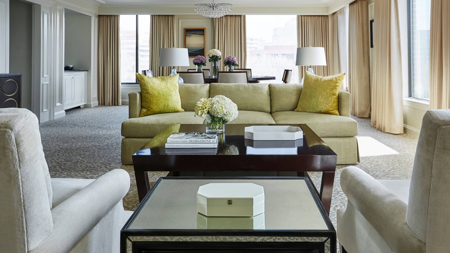 Presidential Suite East Wing living room with two white armchairs yellow sofa and accent pillows in front of dining room