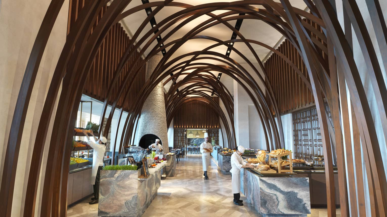 Soaring ceilings, wood arches over marble buffet tables where chefs prepare food