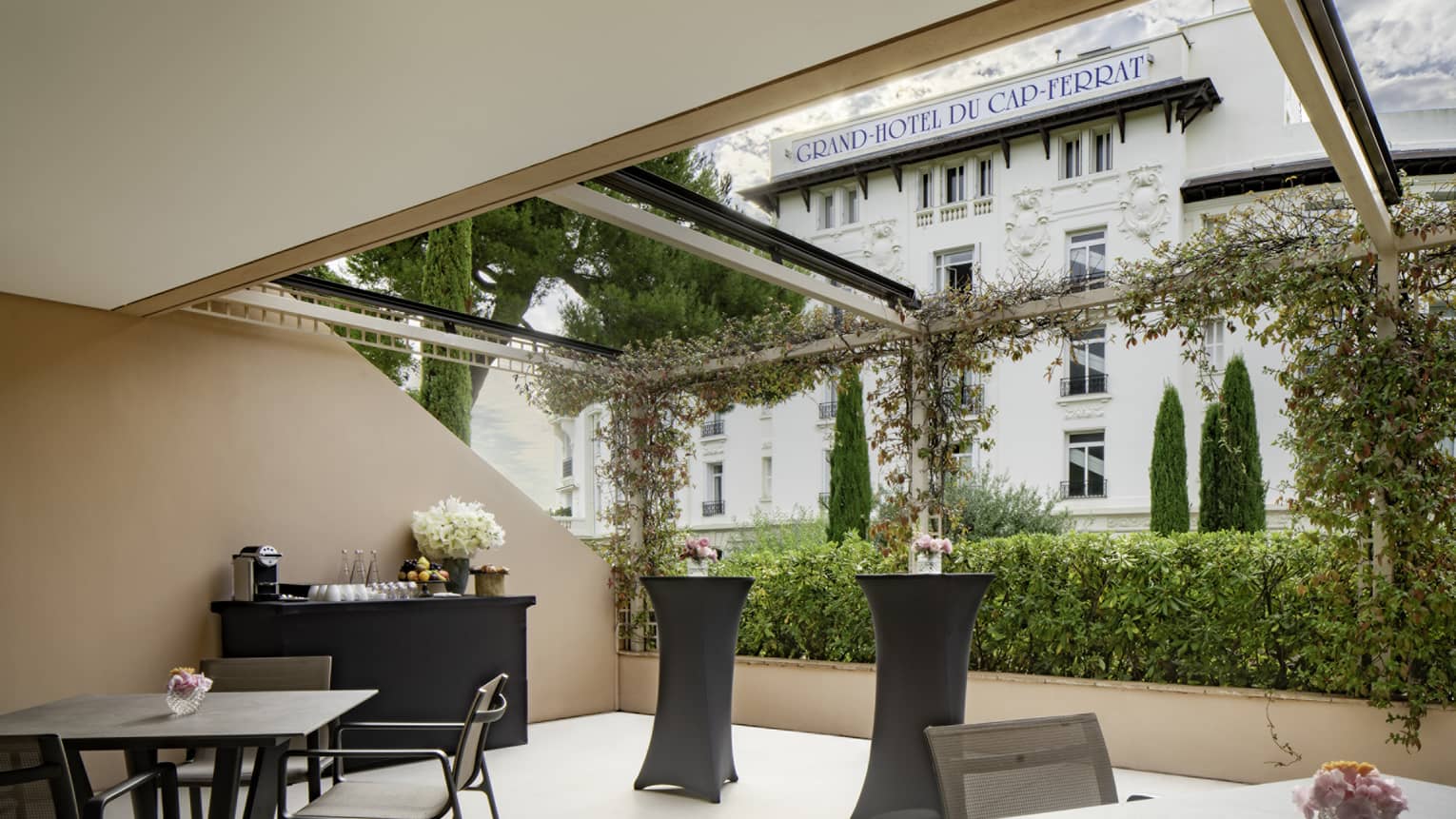 Salon Ferrat venue with square black tables, beverage service setup, open to outside