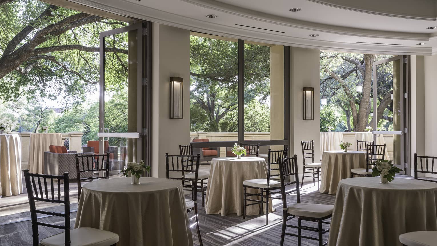 San Jacinto Pre-function room with small tables and chairs by open walls to sunny patio
