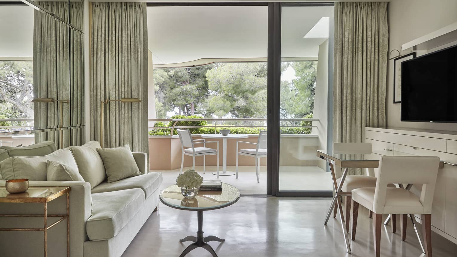 Neutral living room with coffee table, bistro set under TV, large patio doors, patio view