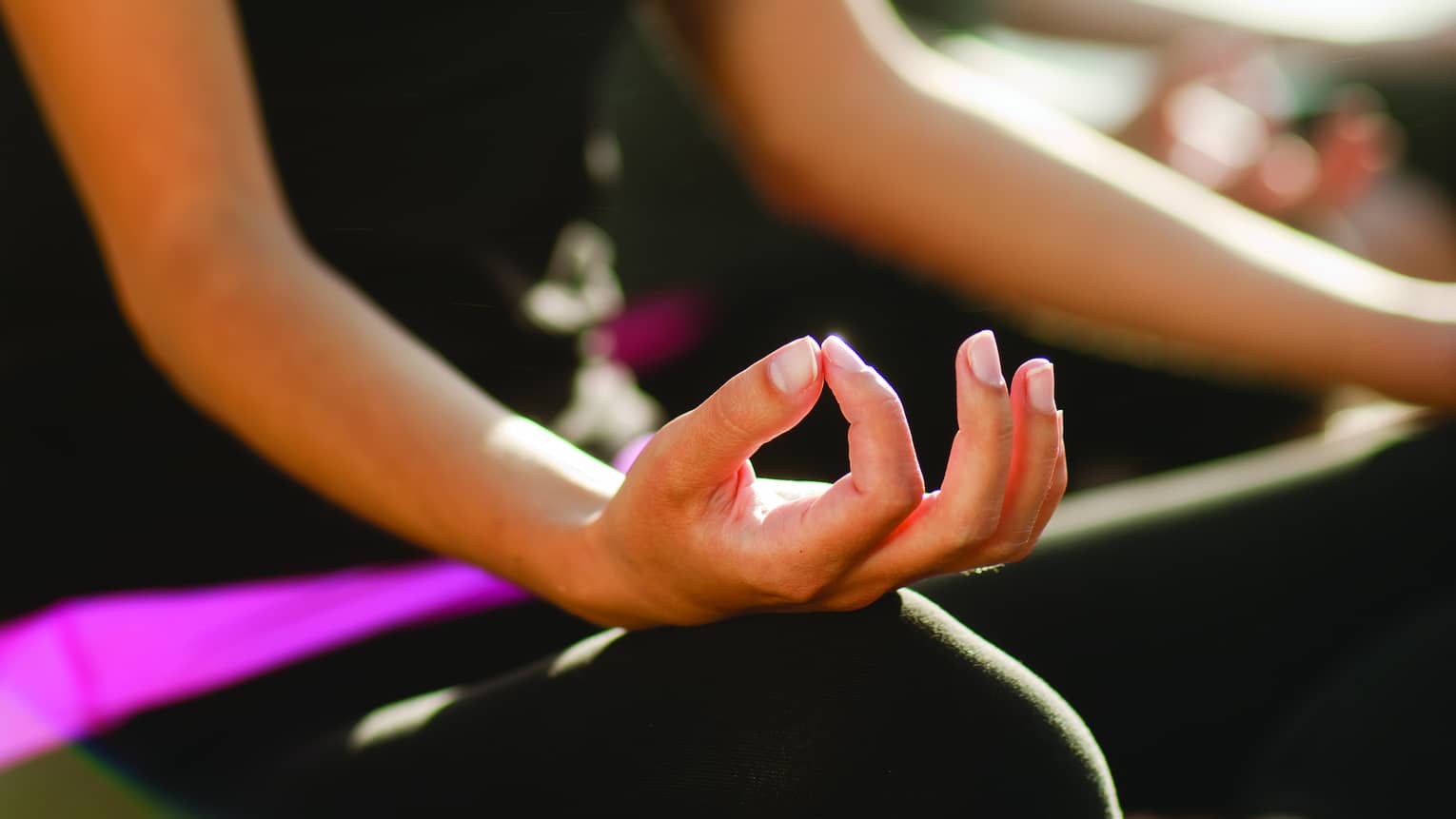 Two women sitting in a yoga pose.