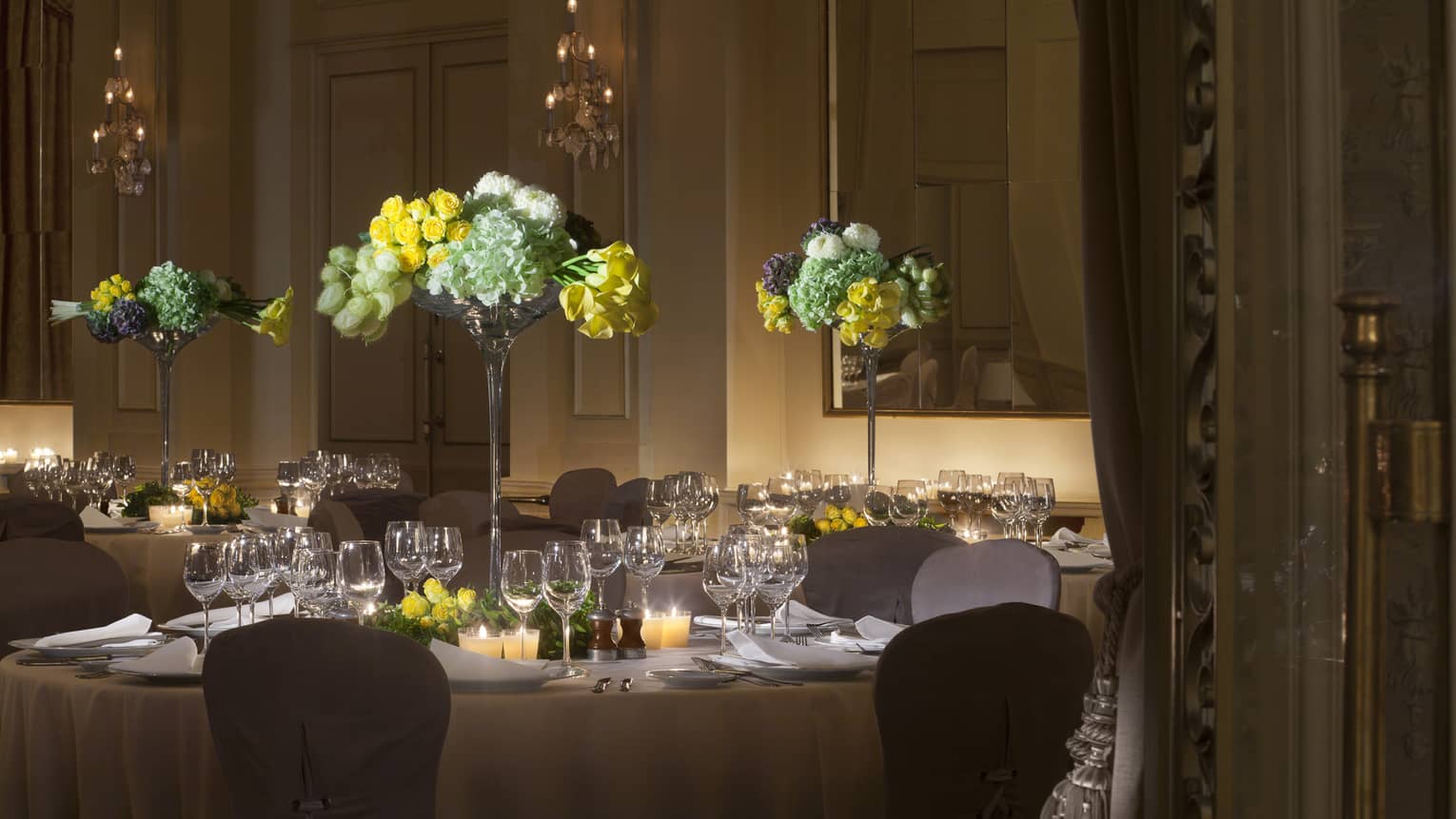 Salle des Nations round banquet dining table with tall floral centrepieces 