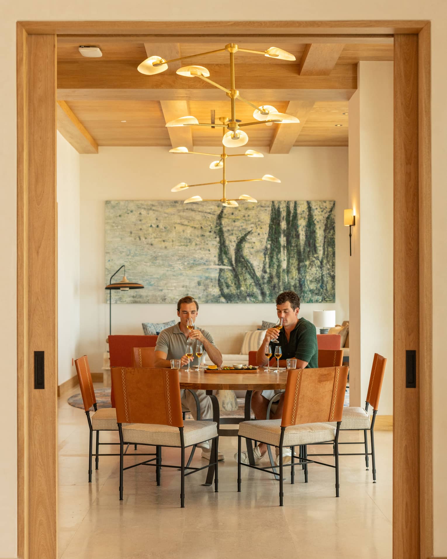 Two people sit at round table in dining room, tasting agave