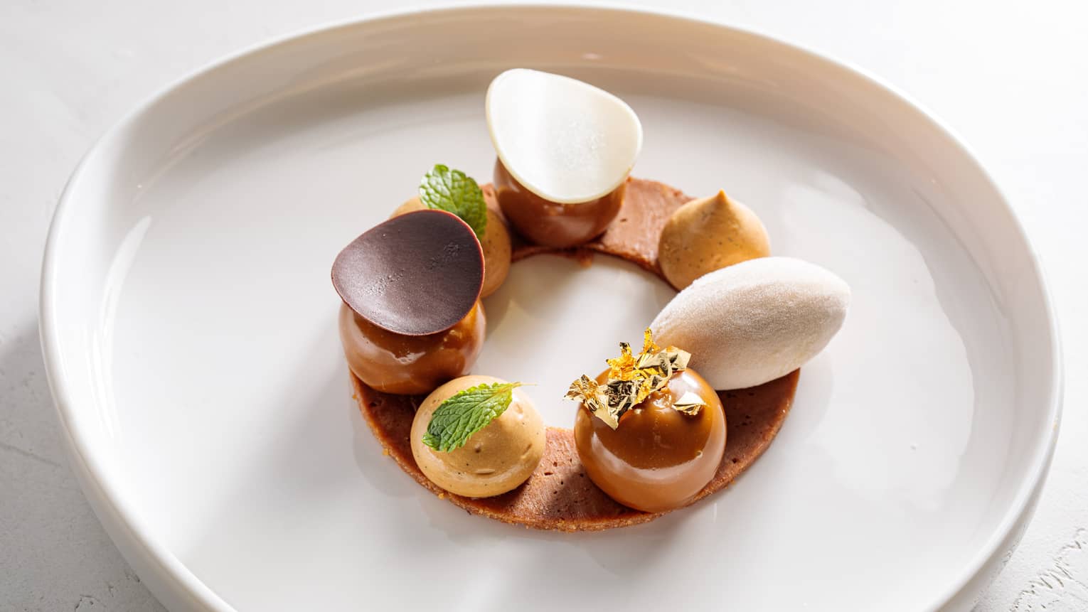 Caramelized chocolate served on a circular chocolate cookie.