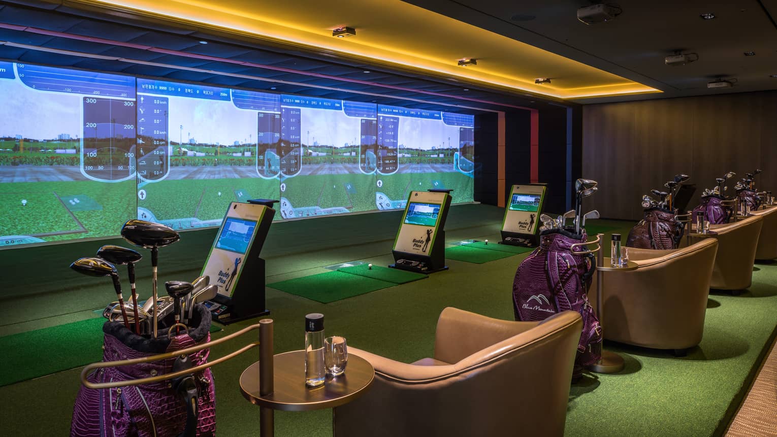 Wall with animated screens, 3D golf course game centre, armchairs with water bottles