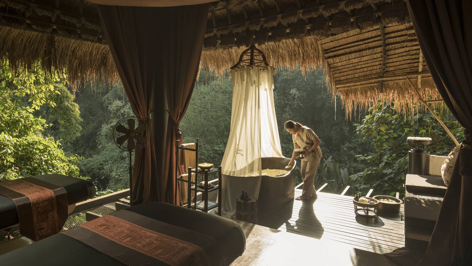 Woman prepares a bath on the jungle terrace