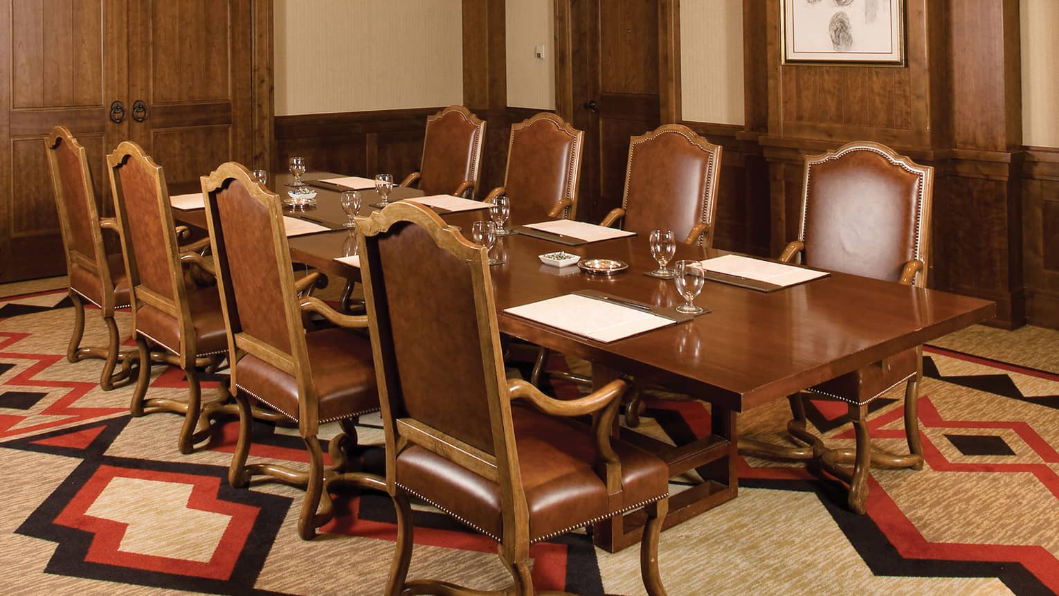 Adler Room with wooden conference table, chairs, wood panels, patterned carpet, ornate light