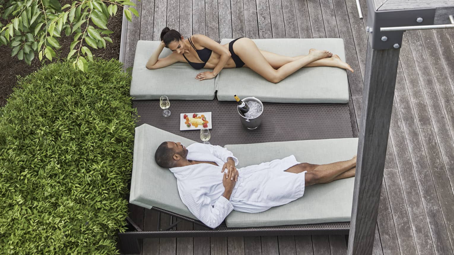 Aerial view of couple lounging in chairs on wood patio