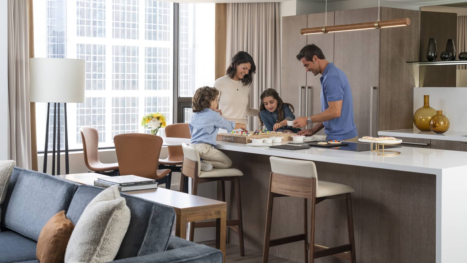 Two children and parents spending time in the kitchen.