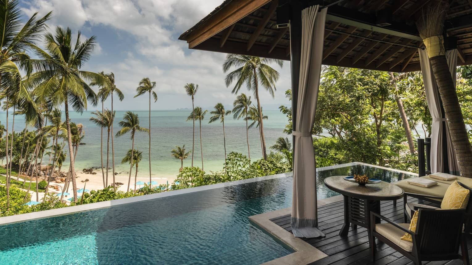 Beachfront Pool Villa small round table on patio by plunge swimming pool, beach and ocean view