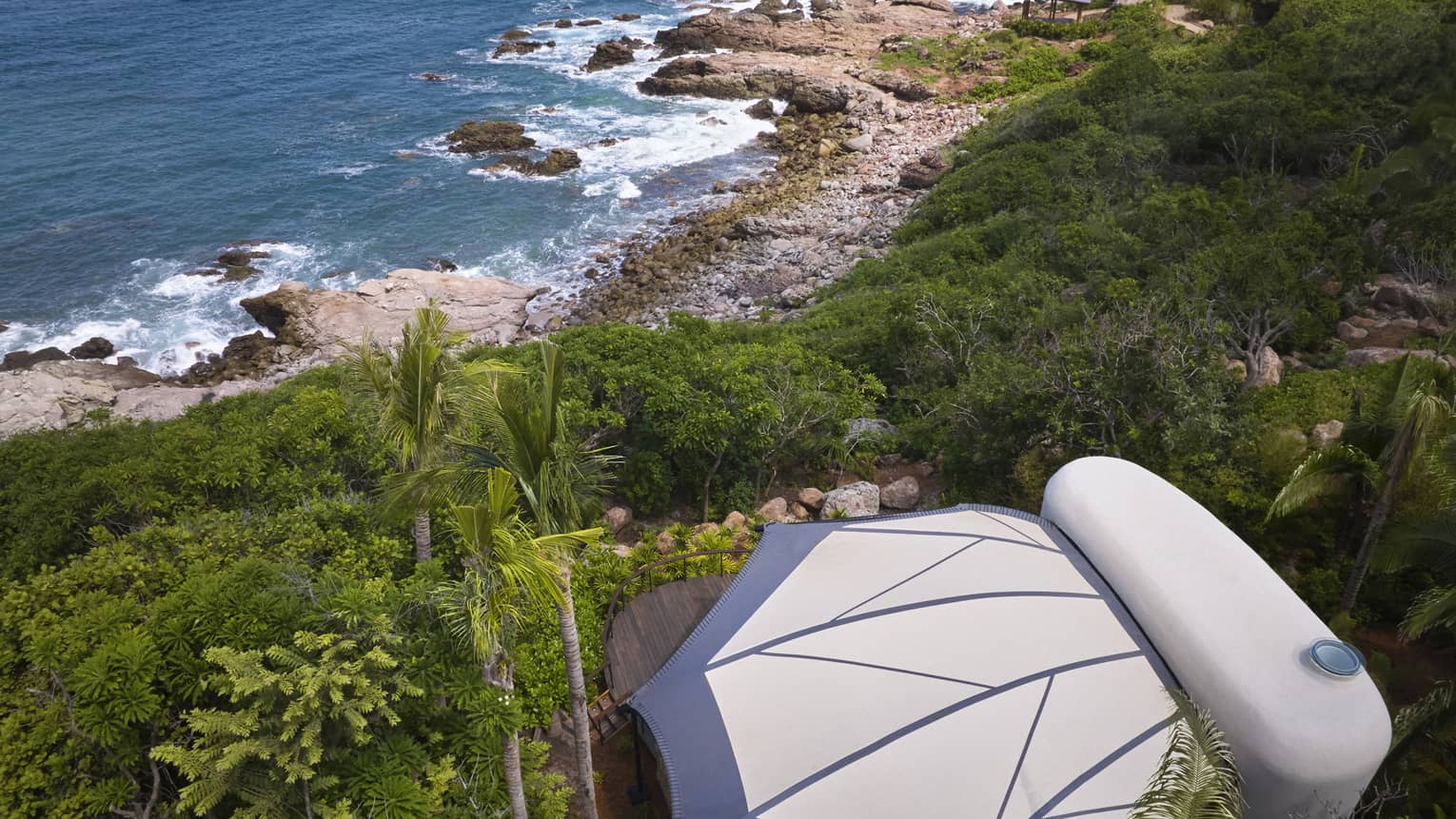 Aerial view of a private luxury tent nestled in the jungle, next to the beach
