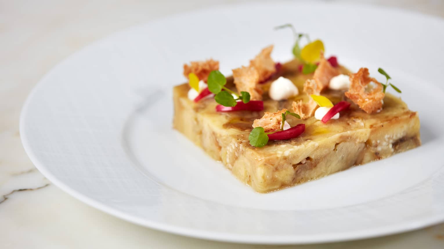 Food shaped into a square with herbs, yogurt and onion no top.