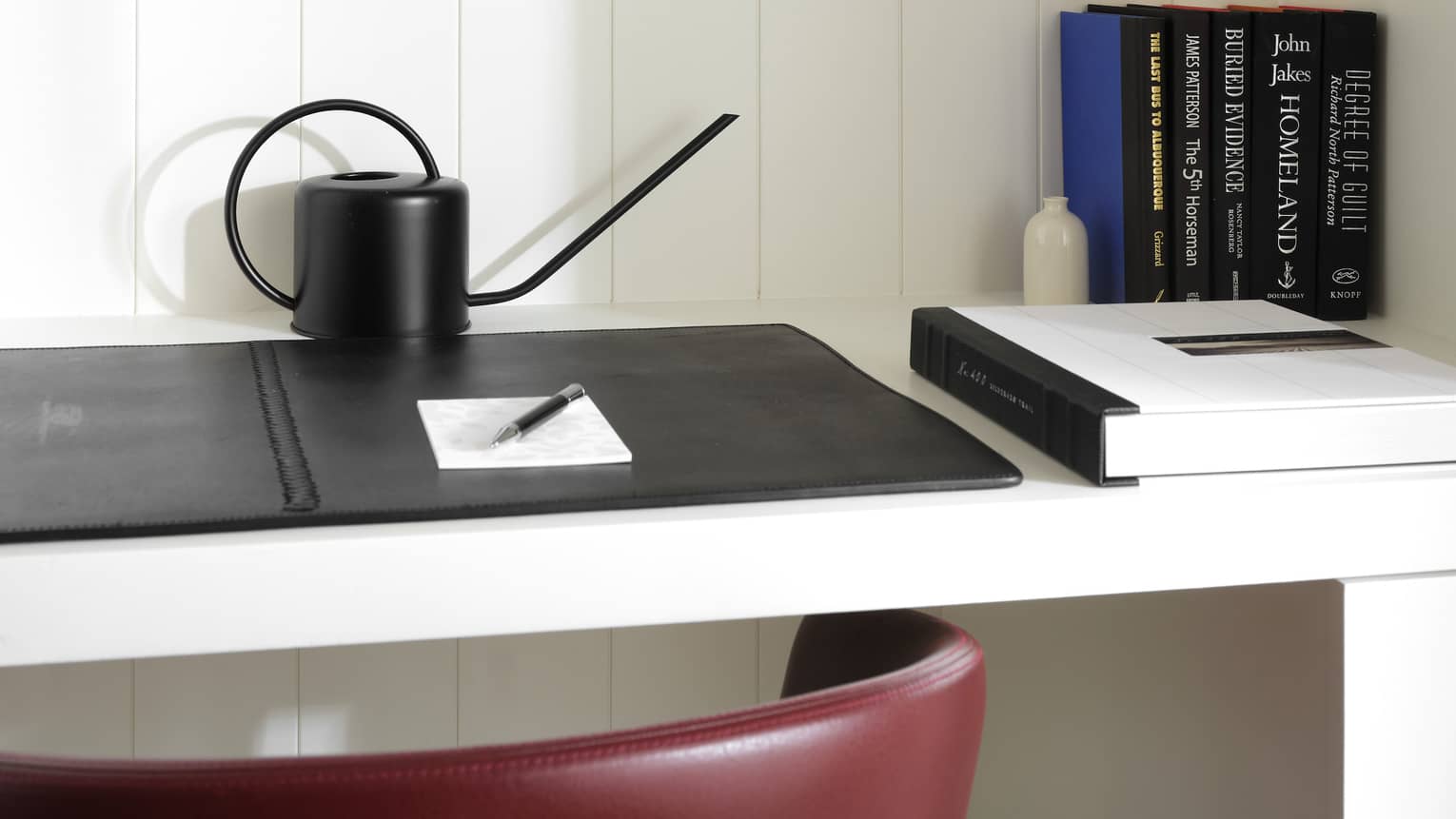 Close-up of a desk, set against a white-wash wall, in luxury resort suite