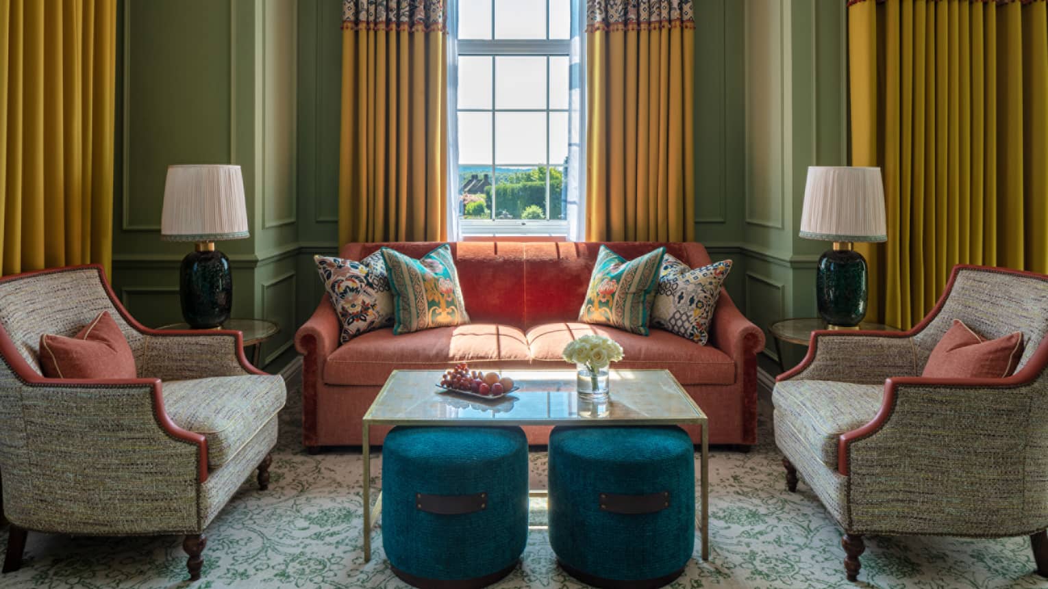 Guest room with red loveseat, matching tan accent chairs, coffee table, avocado-coloured walls, window with yellow drapes