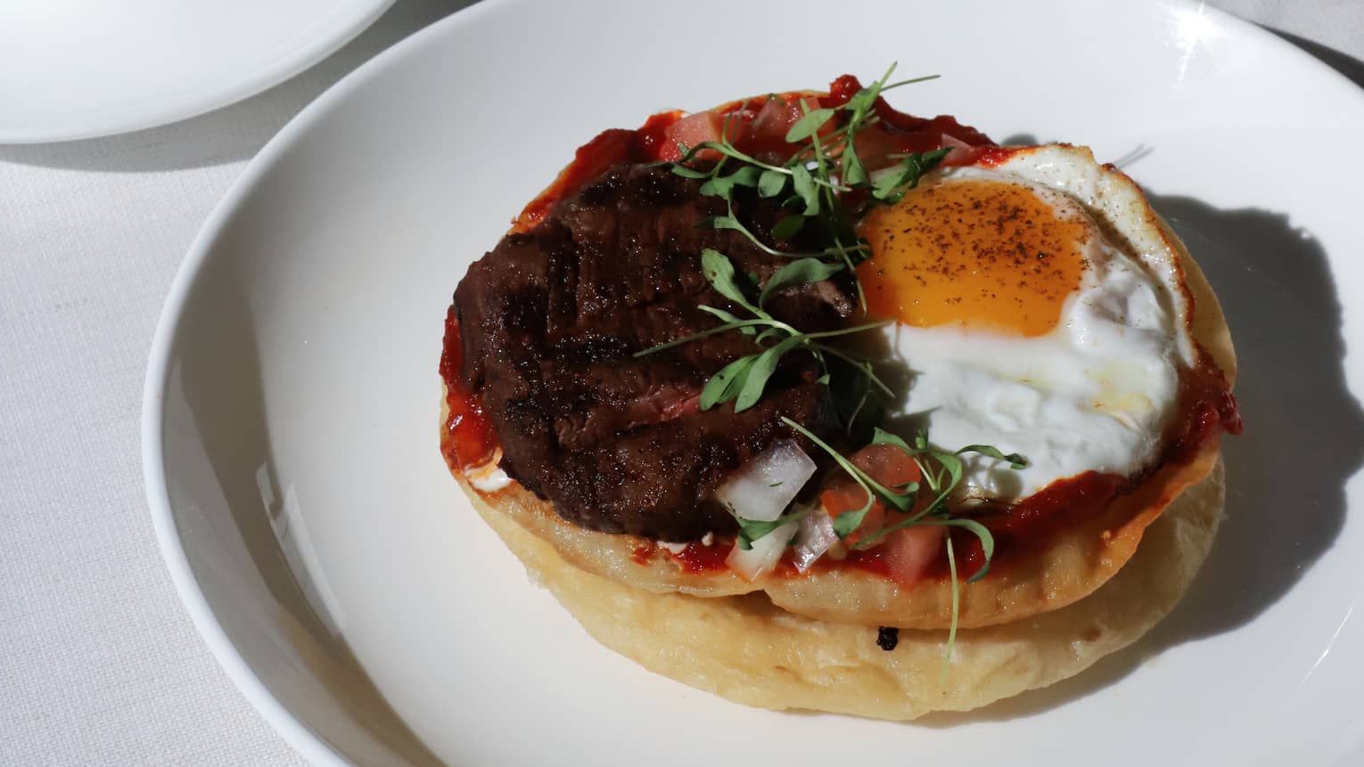 Close up of a table filled with breakfast dishes, green juice and coffee