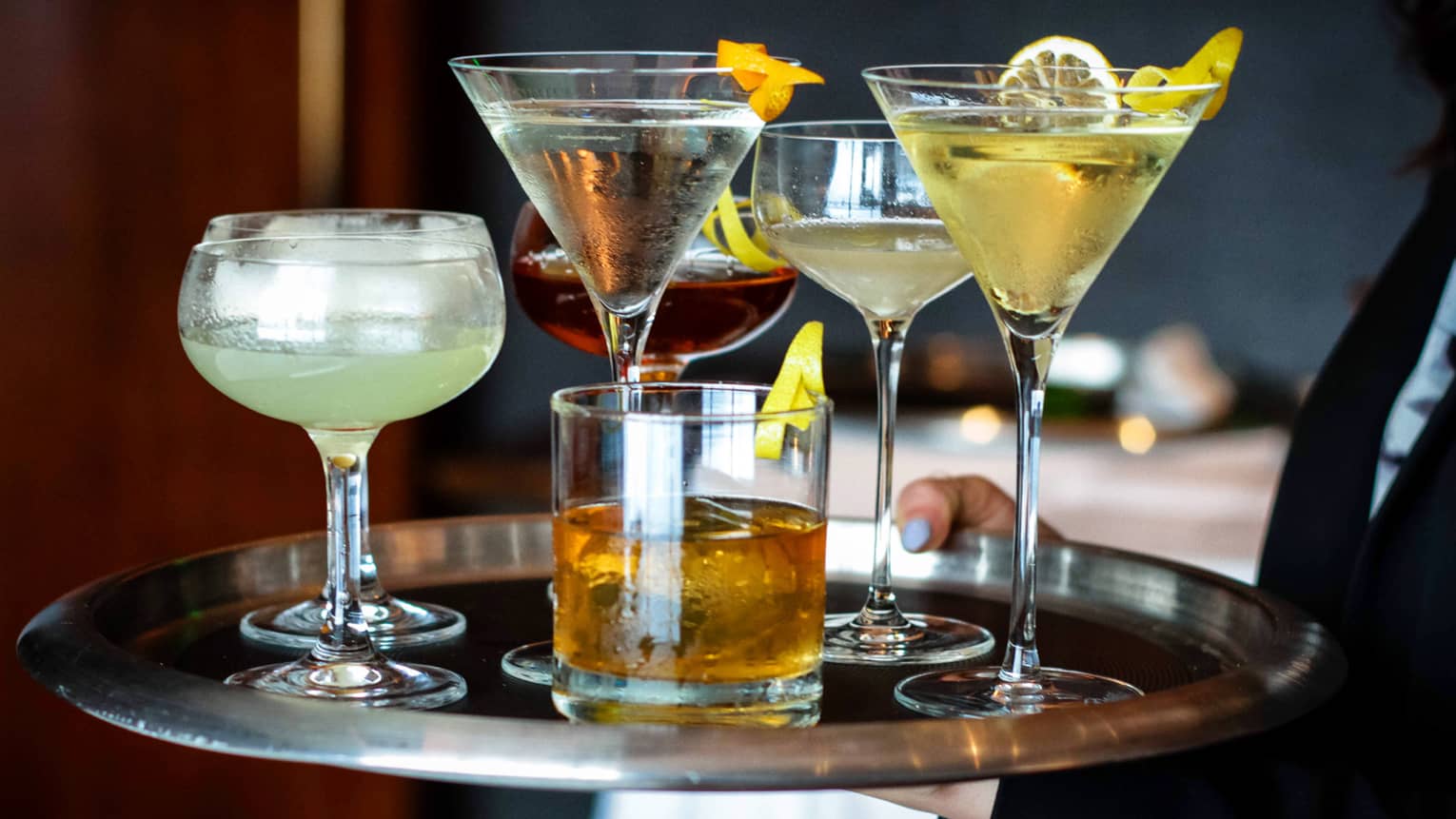 Close-up of silver serving tray with various colourful martinis and cocktails