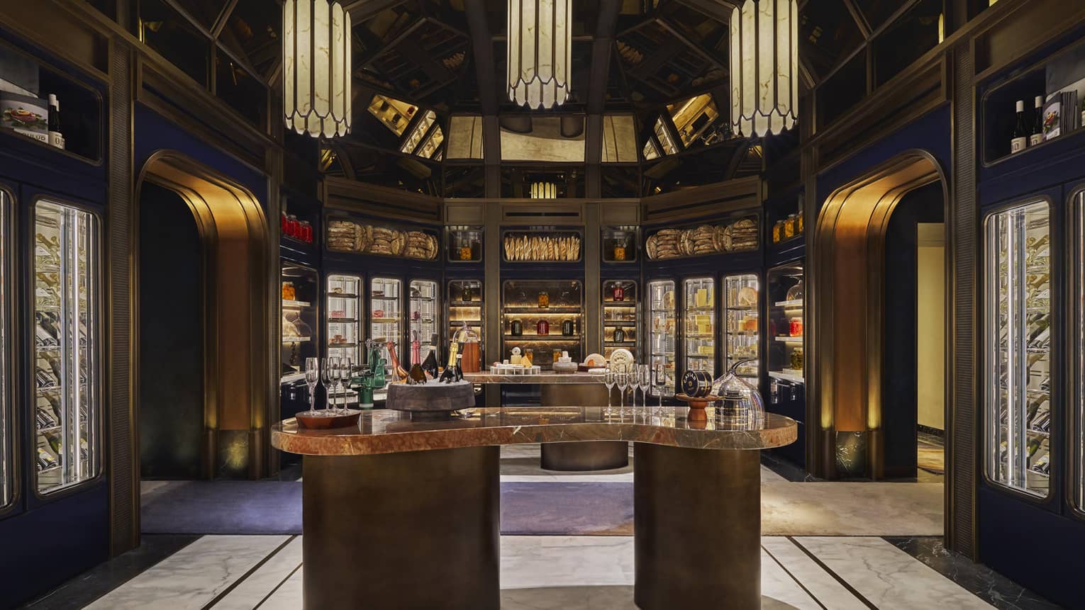 Cheese tasting room with a centre counter surrounded by glass cases of fine cheese and three large lanterns overhead