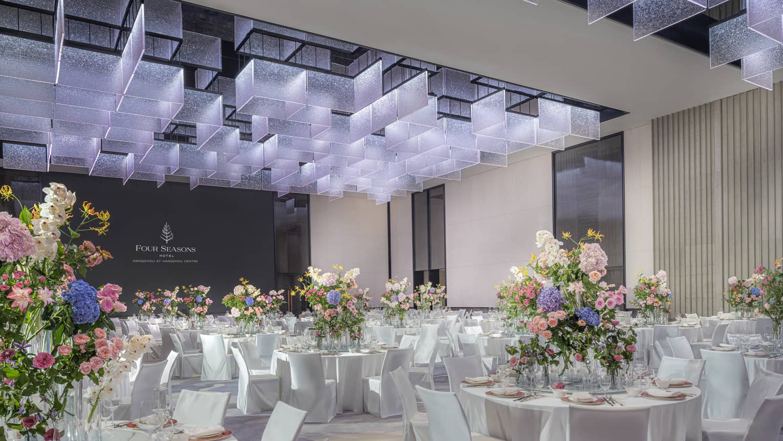 Ballroom with banquet seating and large, colourful floral arrangements