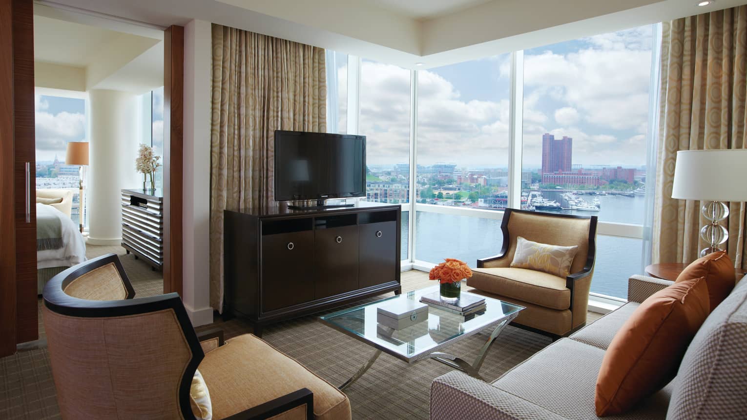 Spacious executive suite with city skyline views, comfortable seating and a large window.