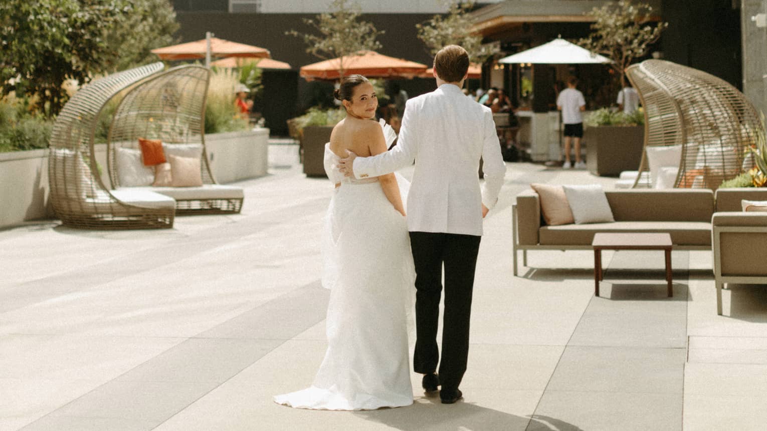 Bride and groom walk down a city sidewalk