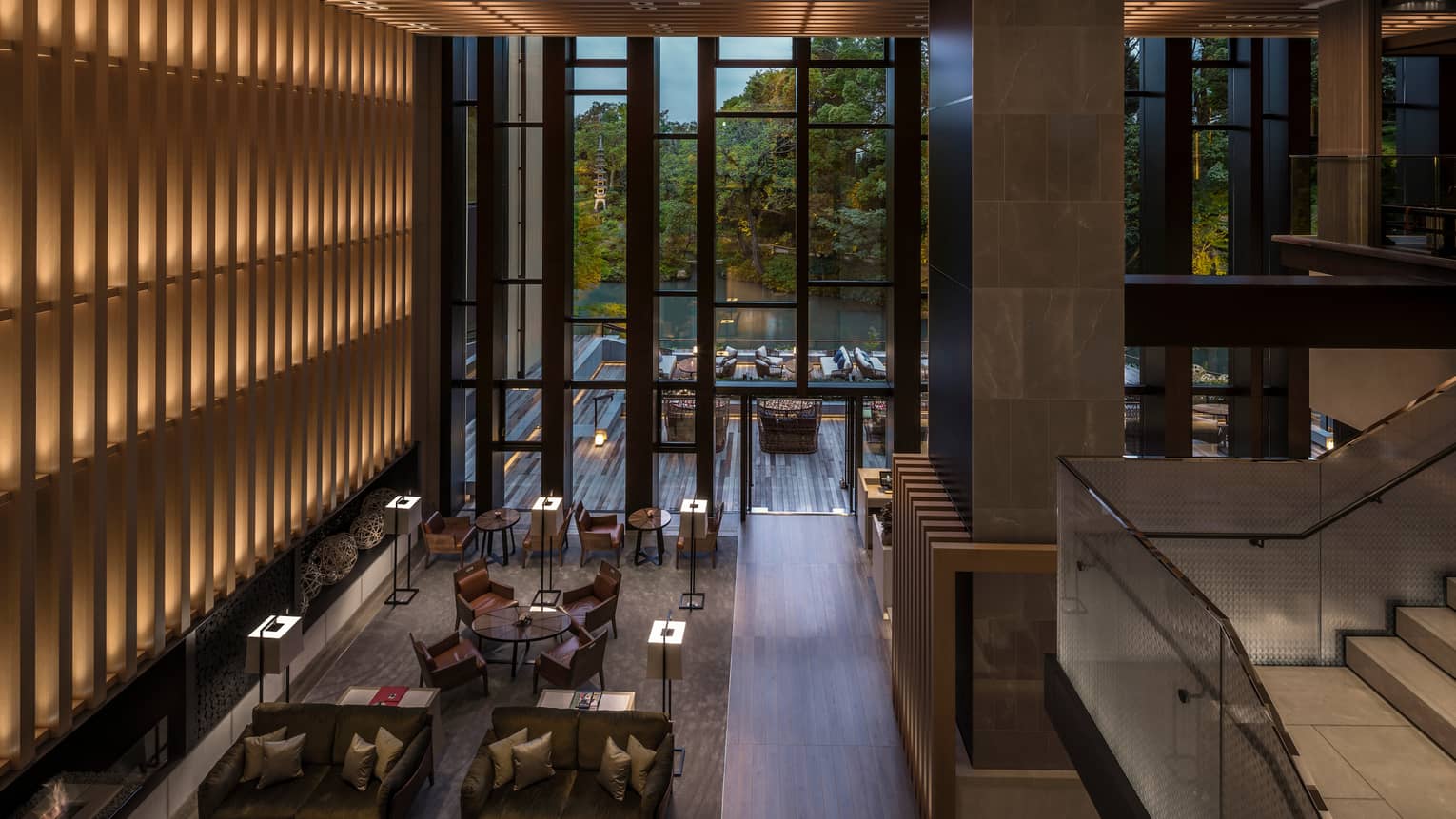 Looking down from soaring ceilings over Brasserie restaurant dining room, wood wall with lights