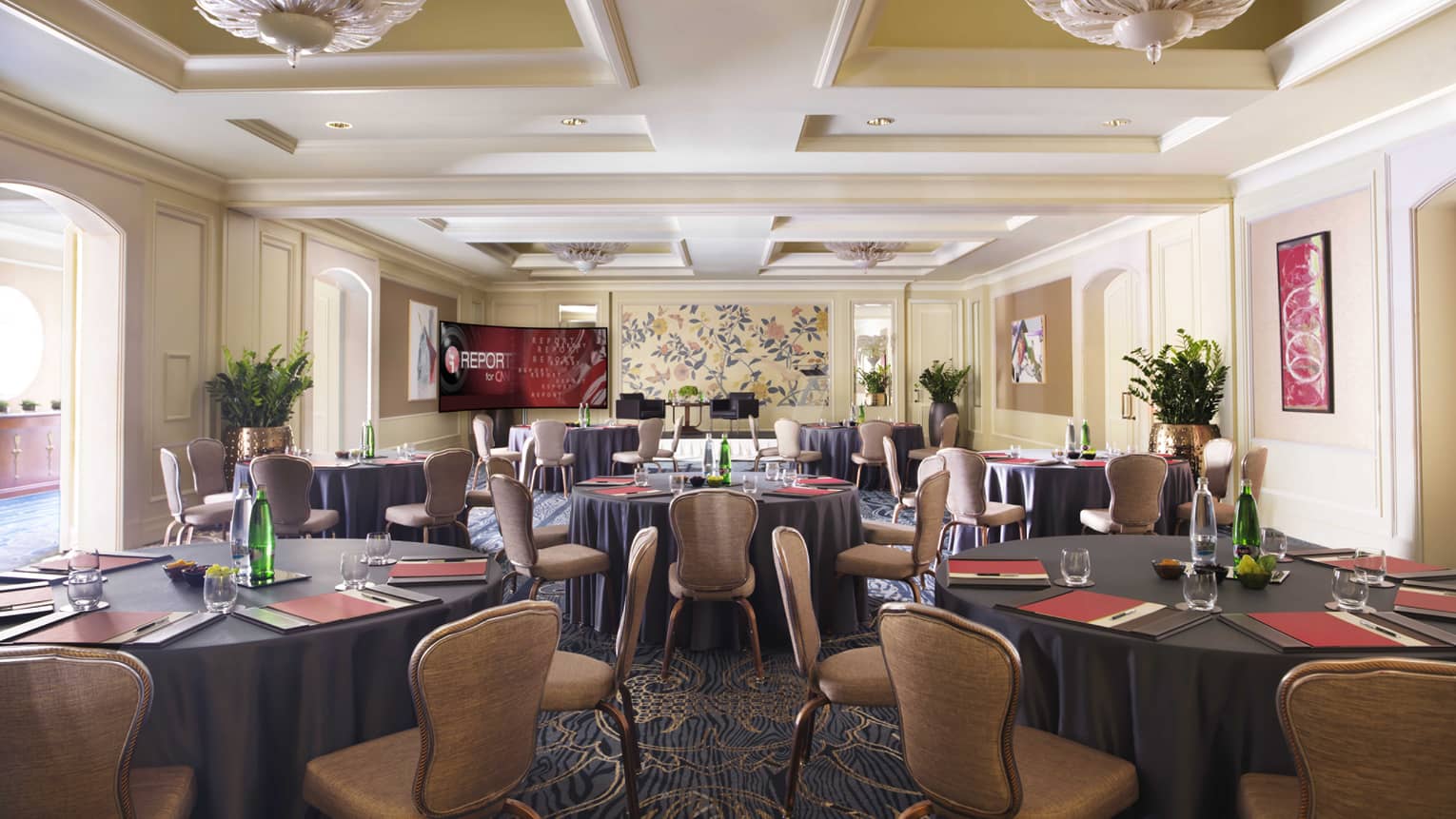 Sunny Karel Meeting Room with round tables lined with tan chairs 