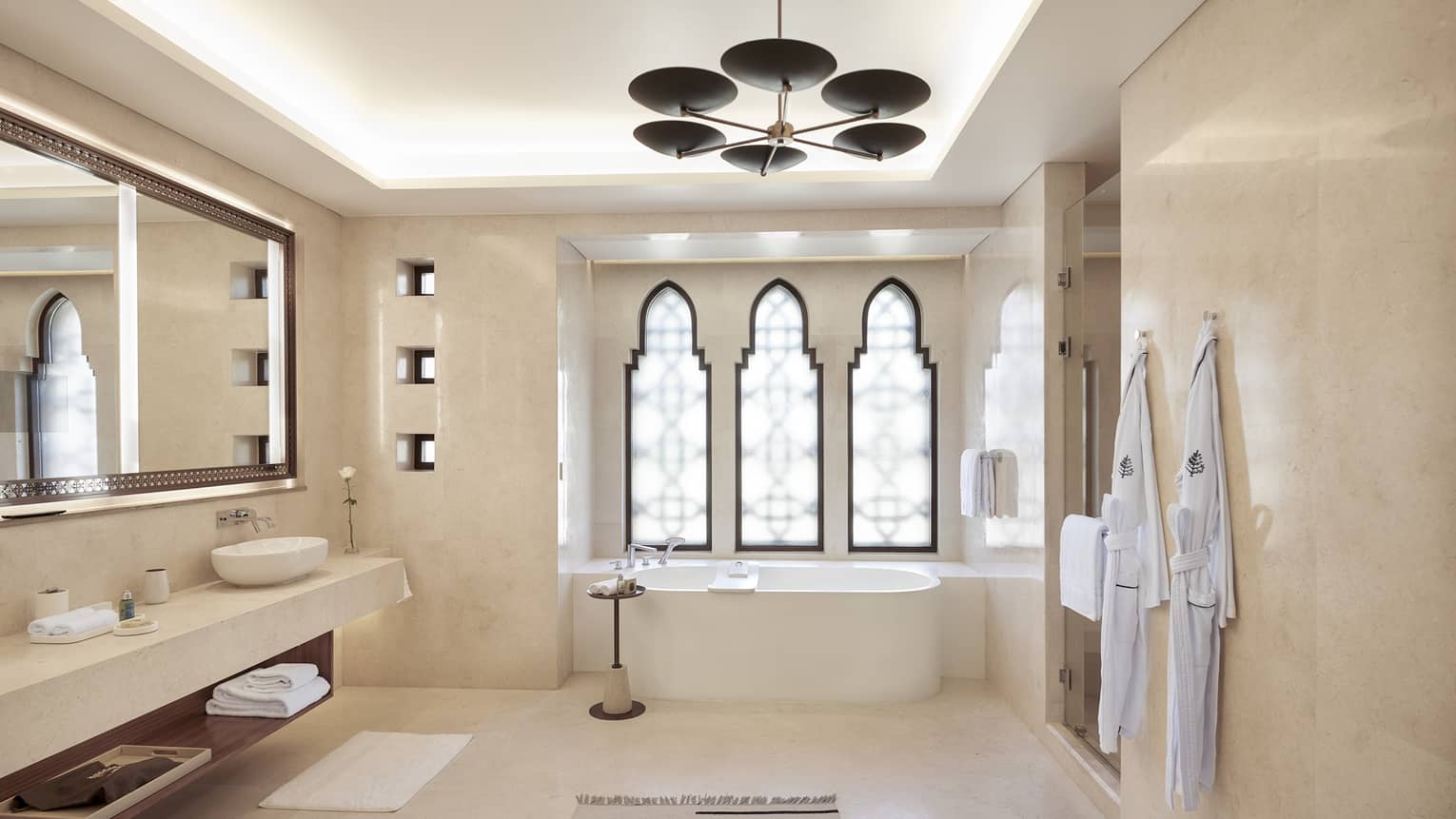 Large bathroom with tub, three windows, long vanity and hanging light
