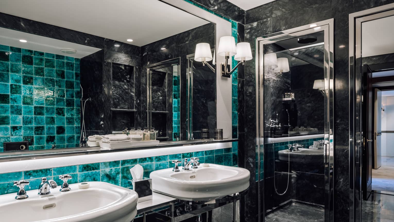 Black marble bathroom with turquoise accent tiles, two sinks, full-width mirror