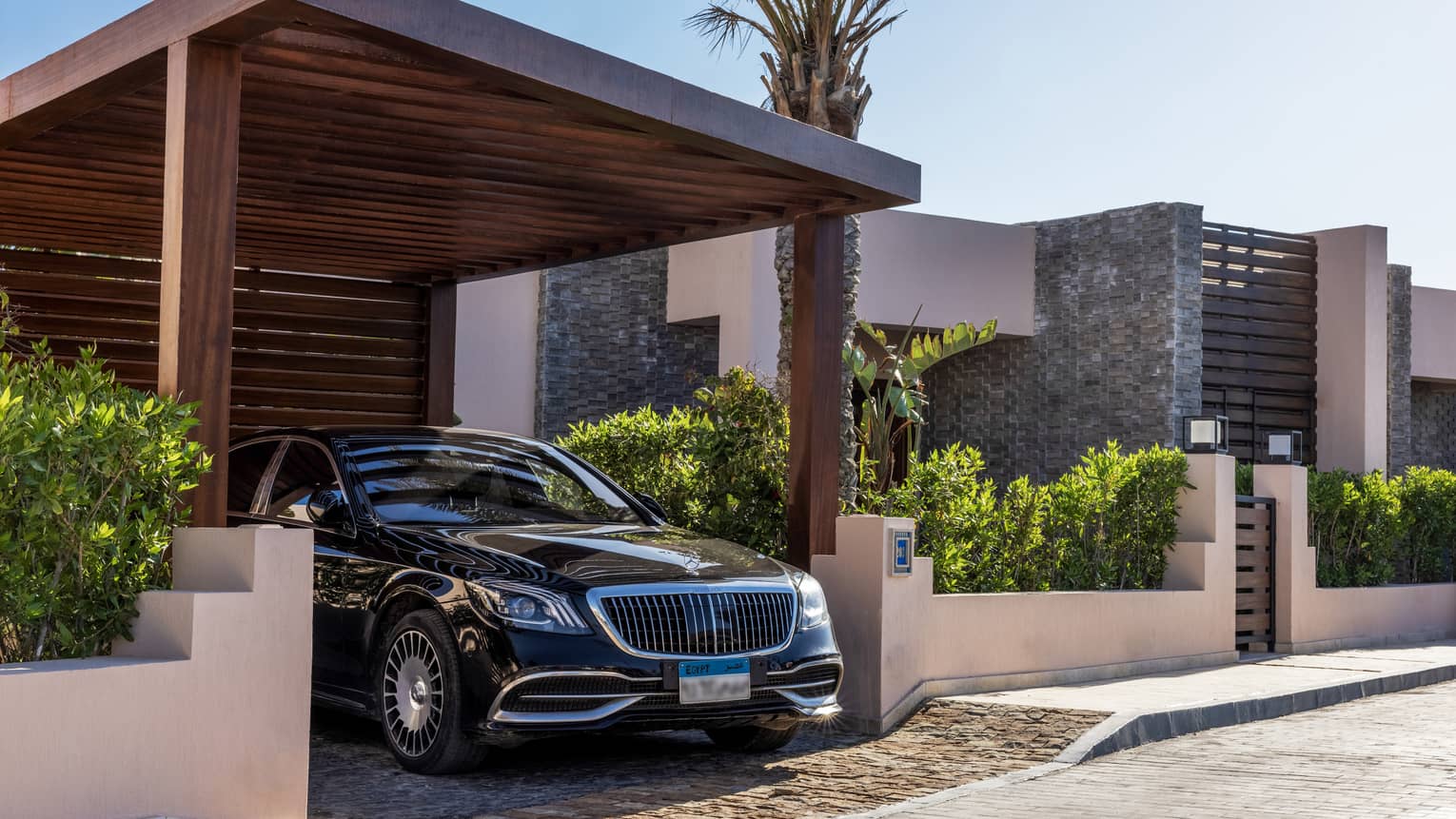 Sleek black hotel car under portico of the One-Bedroom Beach Villa