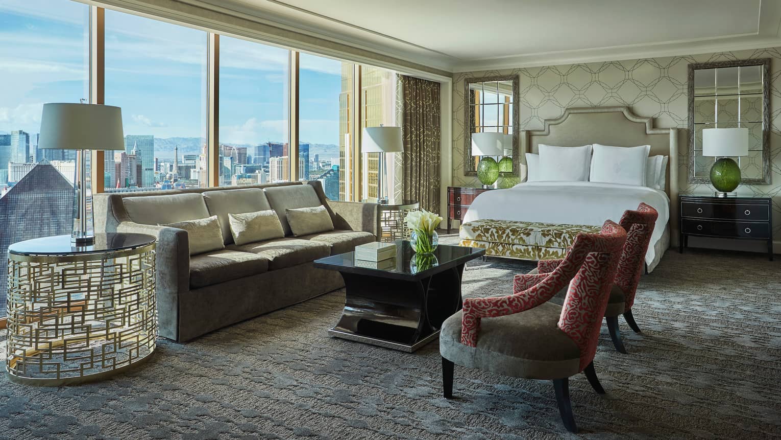 Strip-View Studio grey velvet sofa, gold accent chairs and table, floor-to-ceiling window, city views