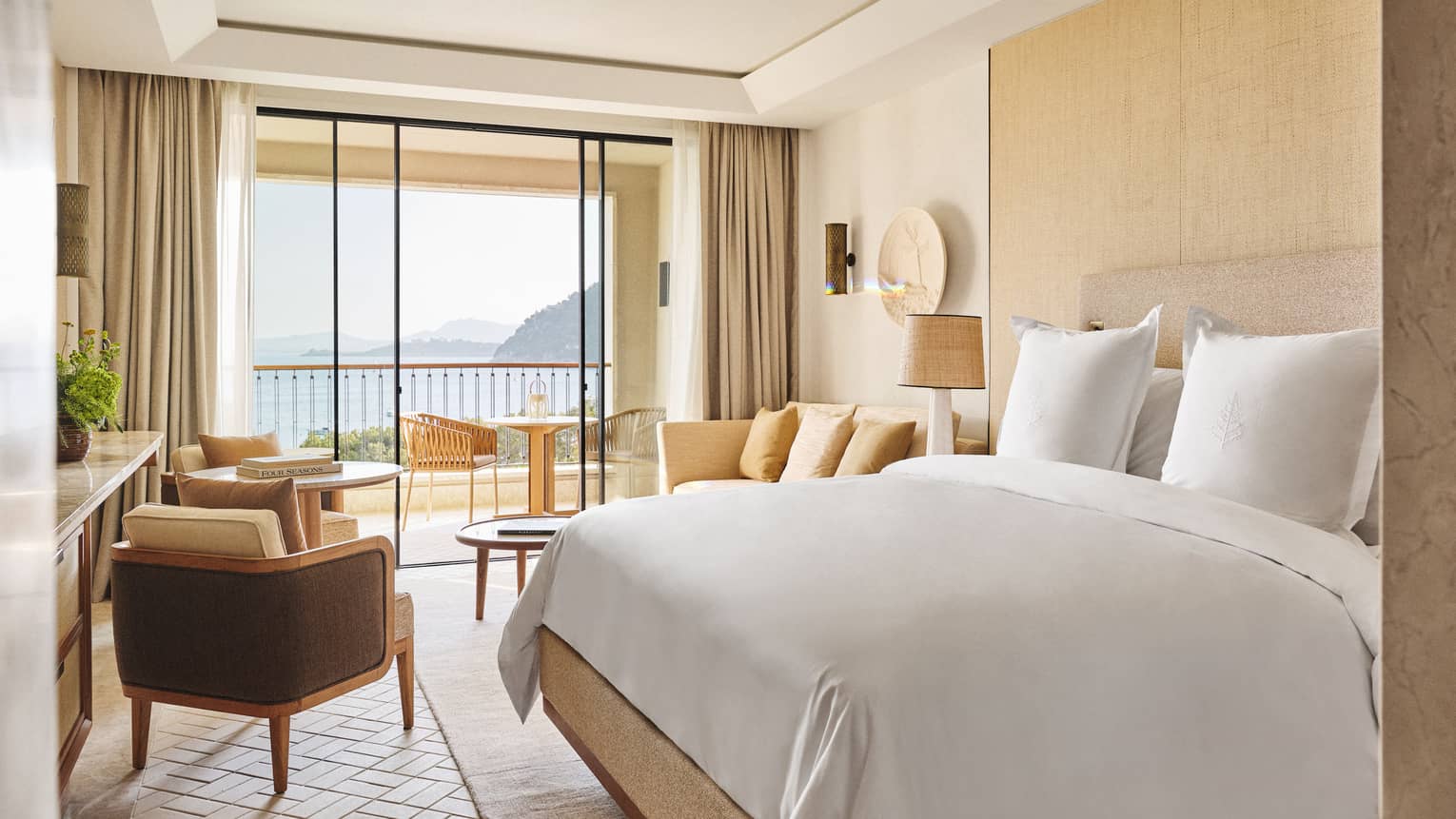 Sea-view room with king bed, table with two chairs, and chaise longue at Four Seasons Resort Mallorca