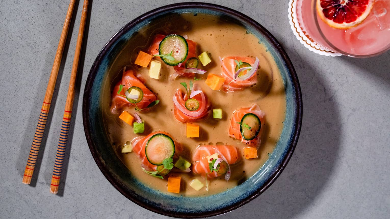 A bowl of raw salmon in an orange sauce.