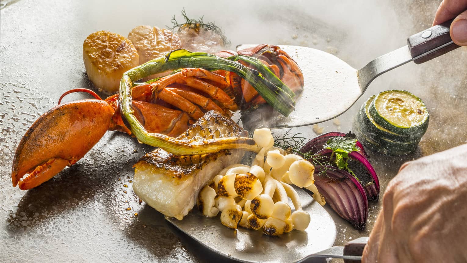 A chef cooks up some teppanyaki on a hot plate