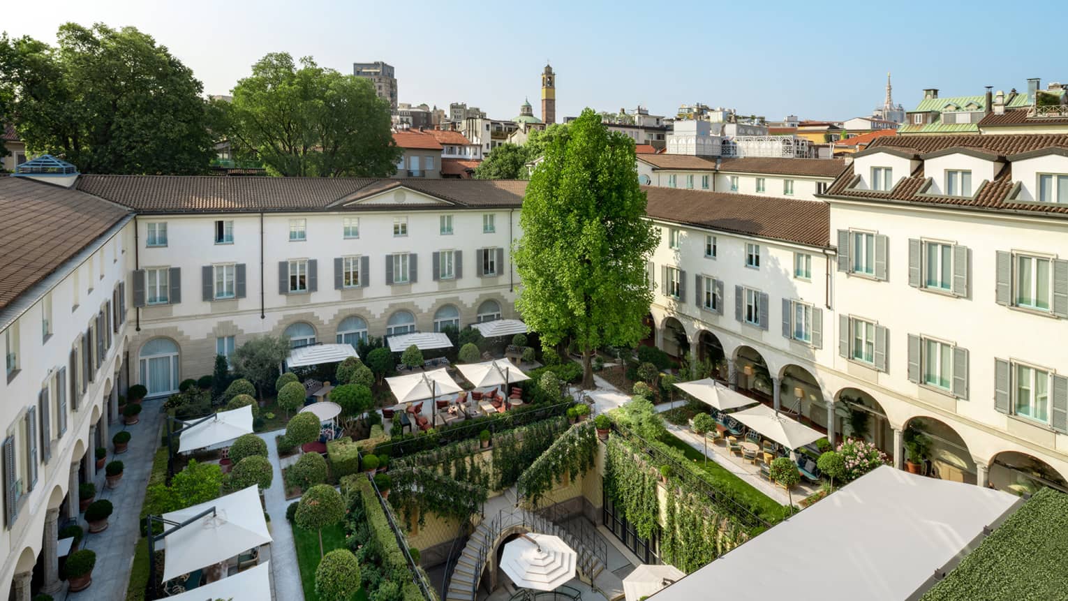 A courtyard adorned in lush greenery and canopied lounges
