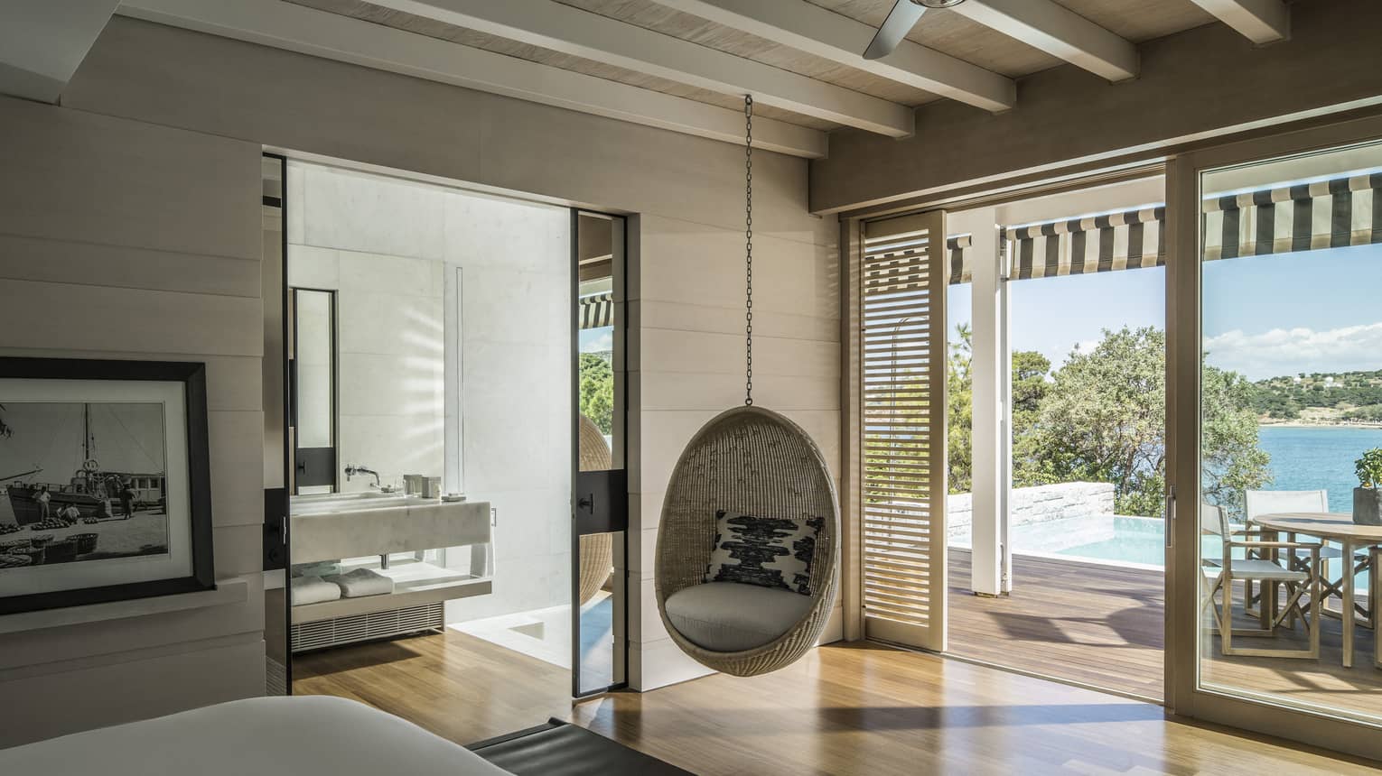 Bungalow Suite with Pool Bedroom with hanging rattan egg chair, mirrored doors to bathroom, sliding glass doors leading to terrace, ocean views
