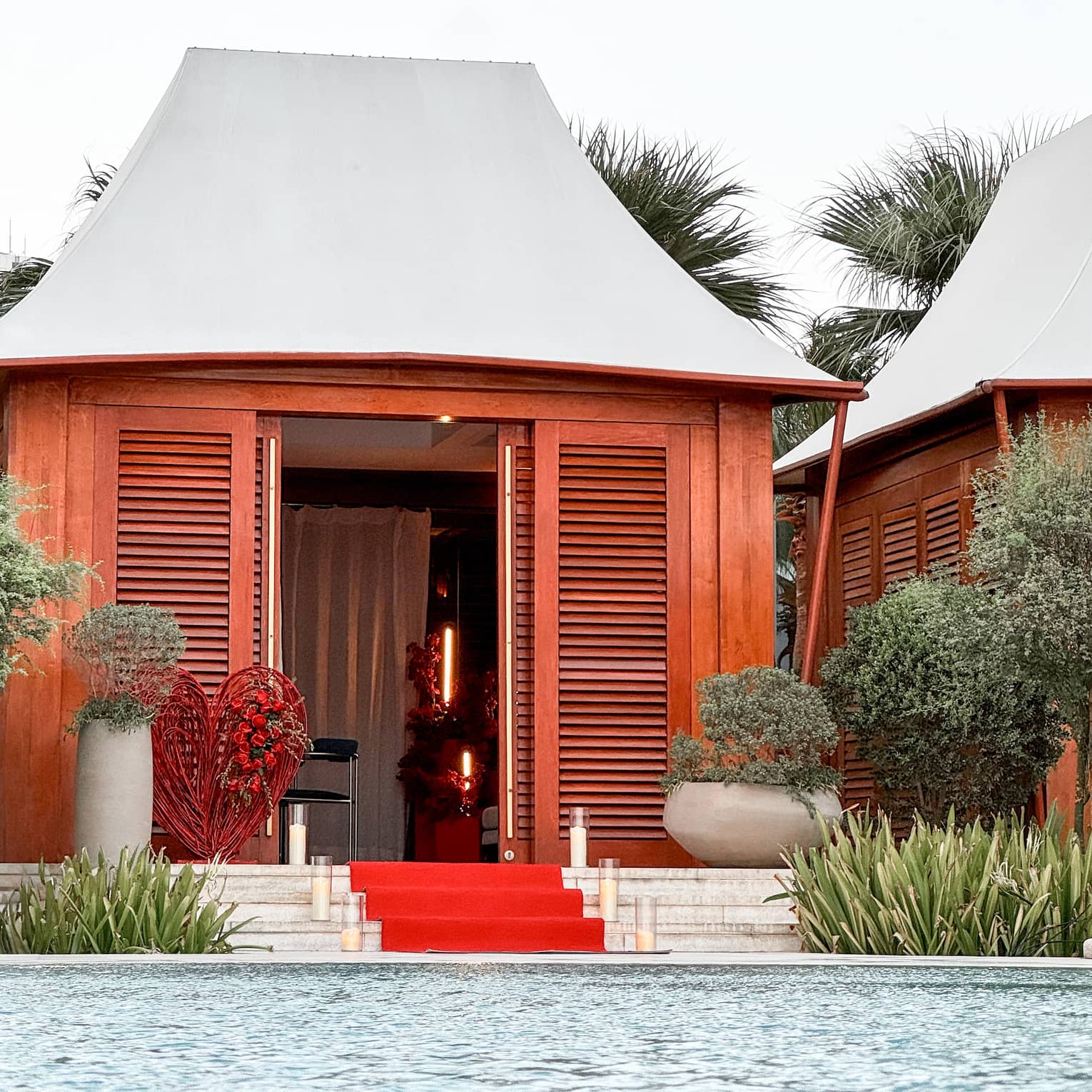 Poolside cabana with red carpet leading up to the entrance