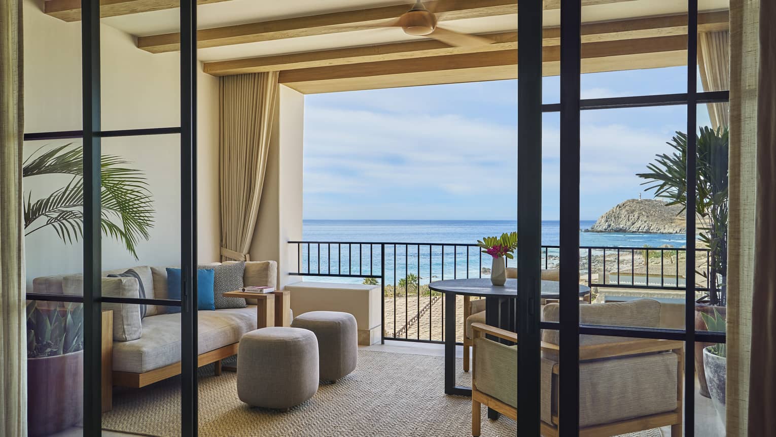 Ocean-view la casona room with a furnished balcony, seating area, a table, potted plants and a view of the ocean and rocky coastline