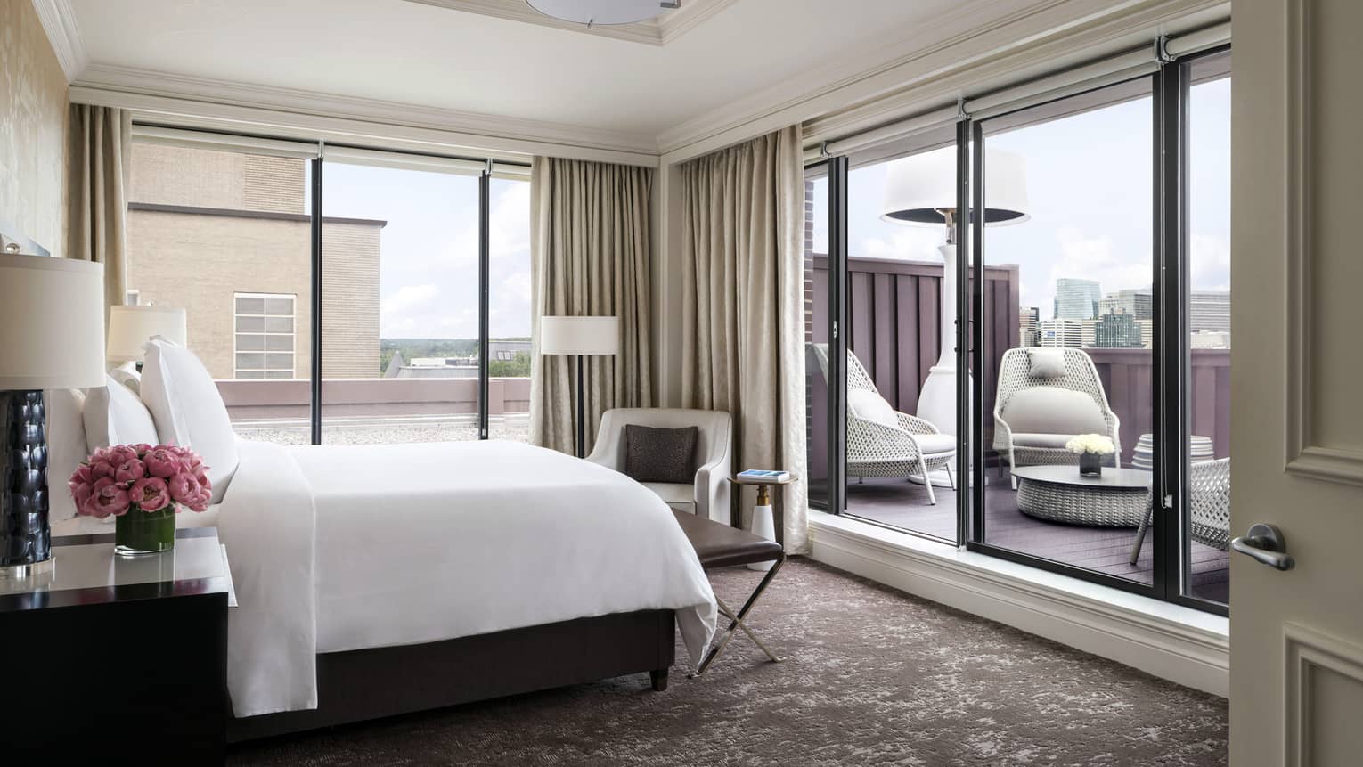 A well-lit suite with a sliding door leading outside to a private terrace
