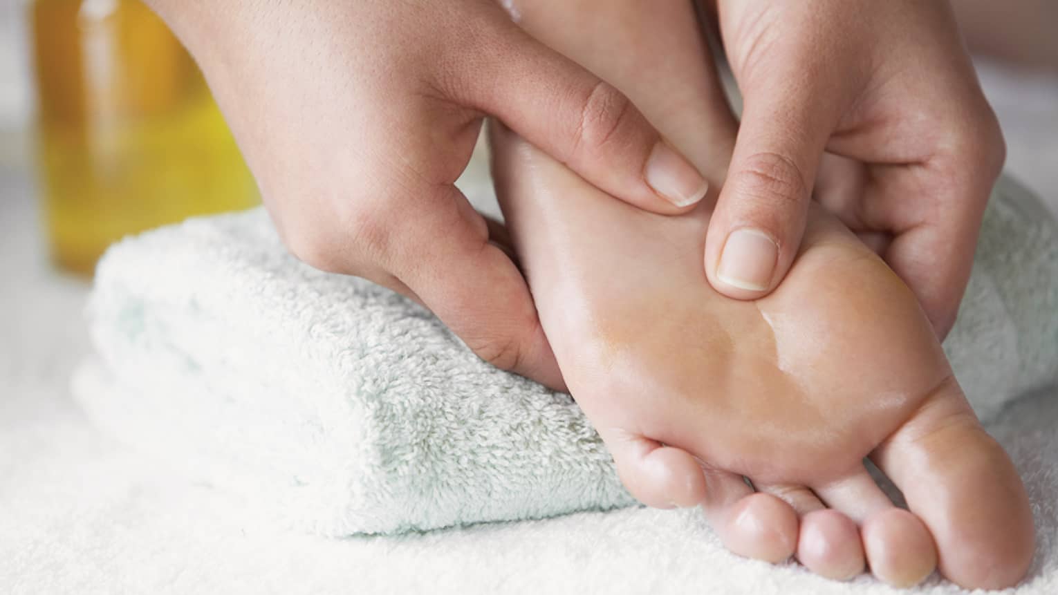Close-up of hands massaging pressure points on feet