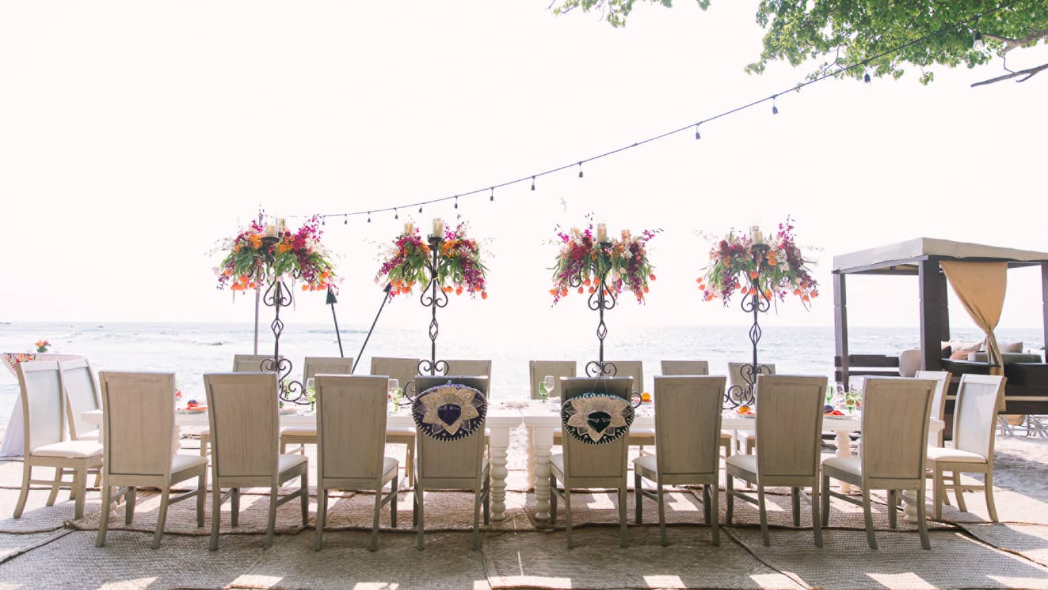 Chairs line sunny outdoor patio dining table with floral arrangements