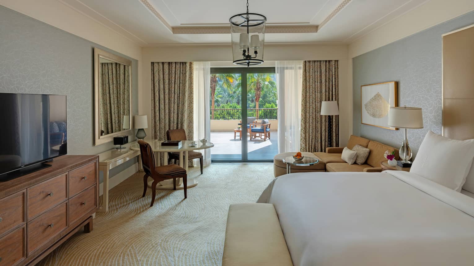 Bedroom with king bed, table and two chairs, sitting area, walk-out terrace