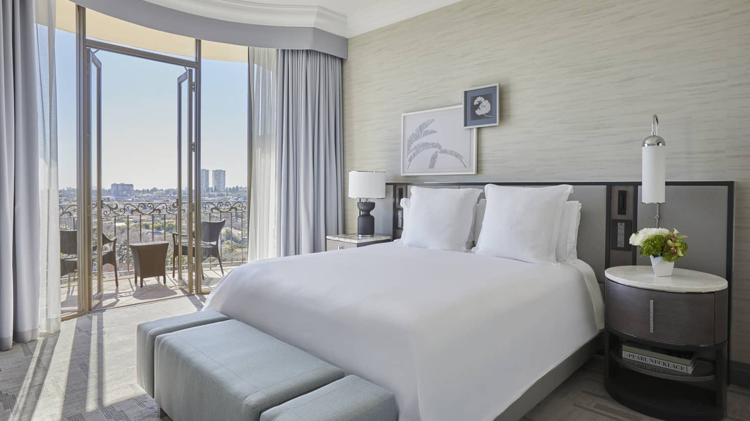 Hotel room with king bed and city-view balcony