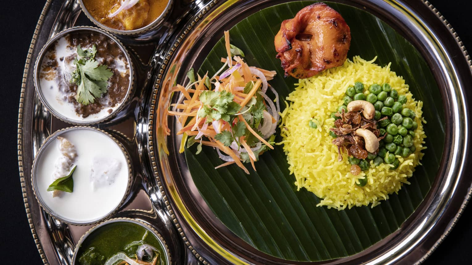 Indian food including rice, four sauces and vegetables.