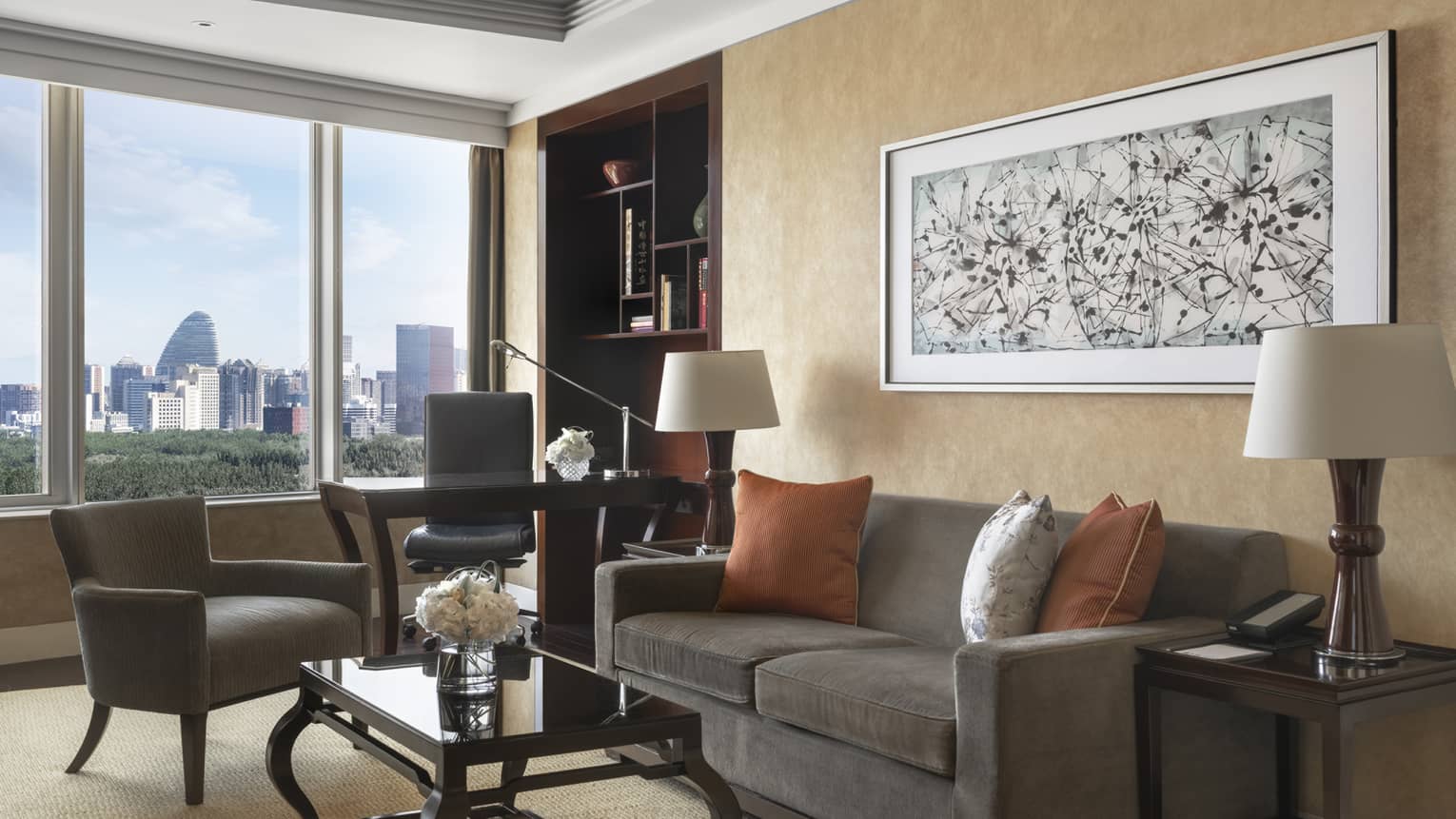 Living room with dark grey, two-seat sofa, chair, desk and chair, and window
