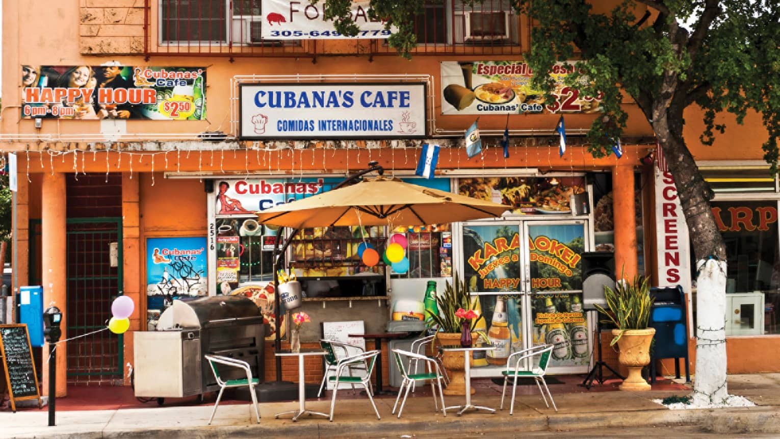 Exterior of colourful Cuban cafe with tables and chairs at Little Havana in the Calle Ocho
