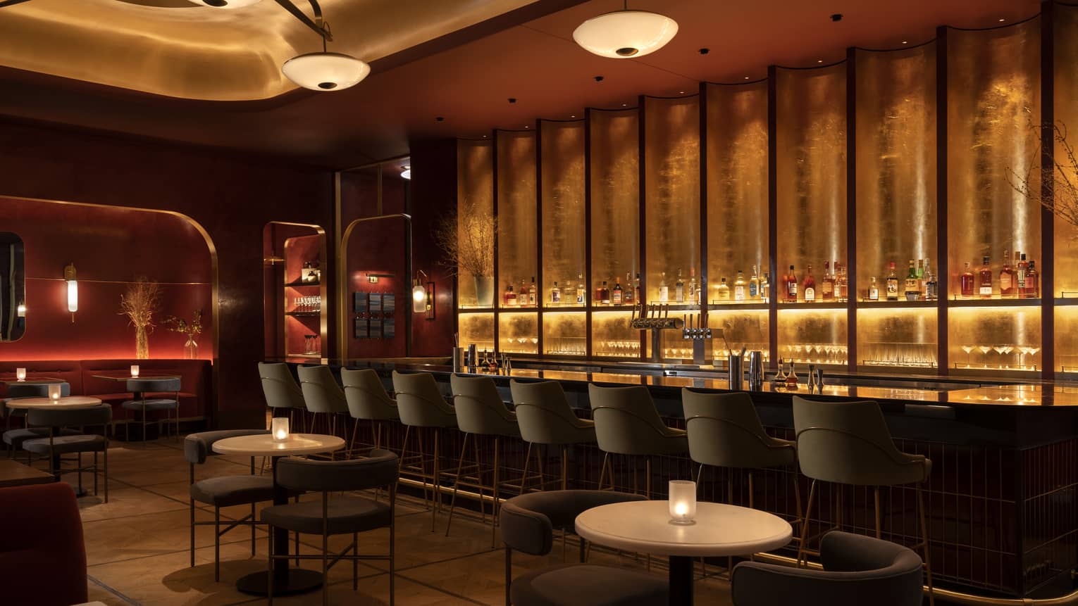 Interior of a dining room and bar with mid century modern seating, illuminated by warm lighting
