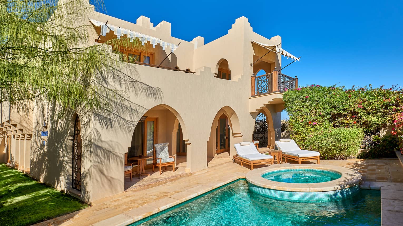 Exterior view of four bedroom villa and private pool against blue sky