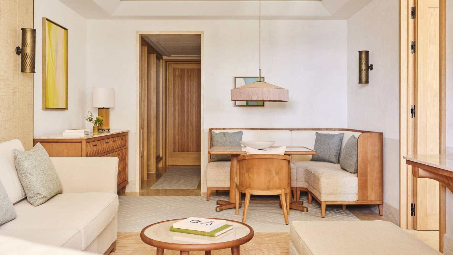 Suite living room with dining area and living room, featuring modern wooden furniture with natural colours, at Four Seasons Resort Mallorca