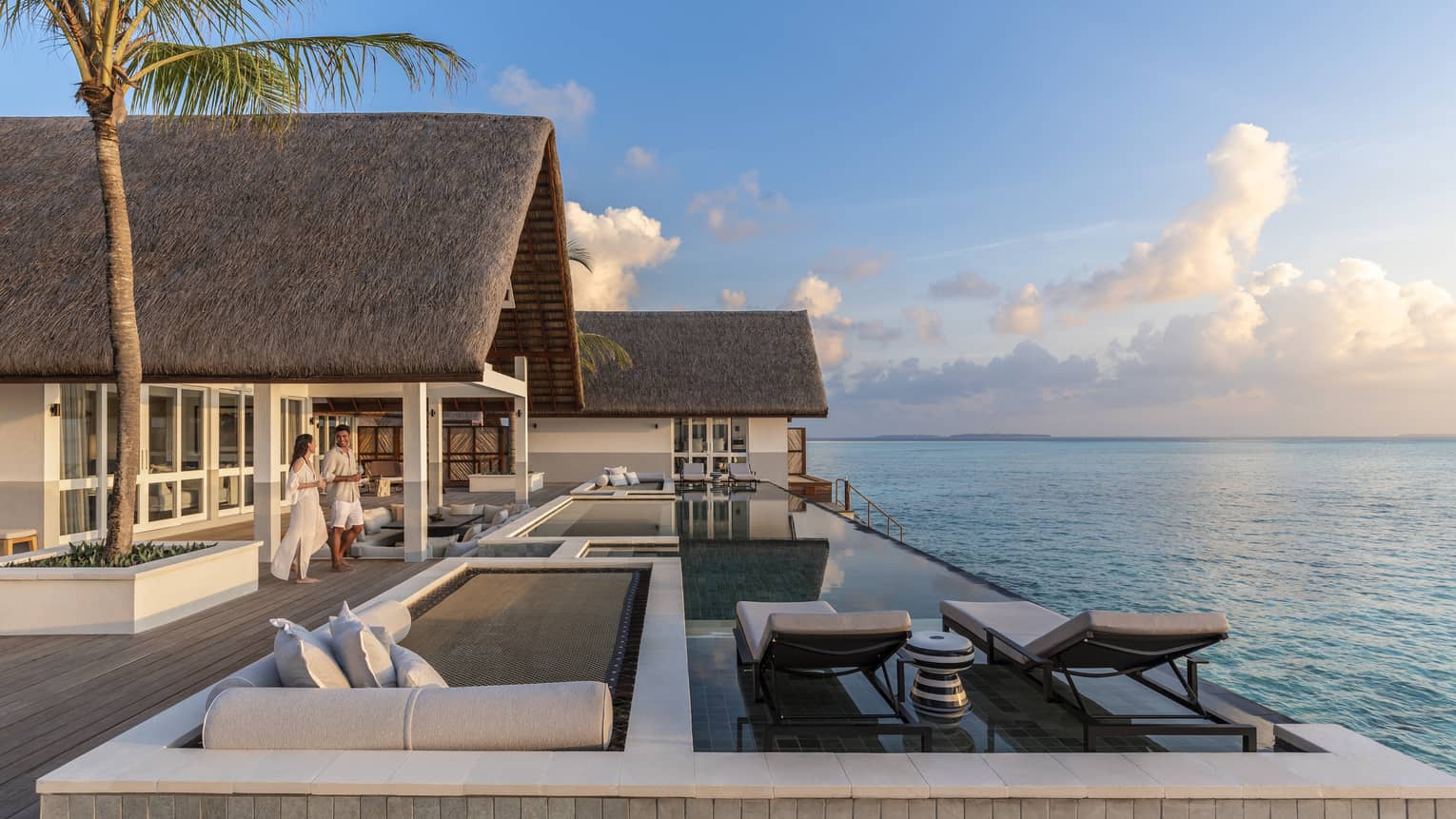 Couple walk out to large patio of Three Bedroom Water Suite